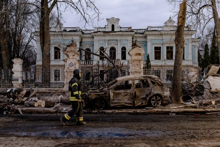 SUMY, UKRAINE - APRIL 13: A Ukrainian rescuer walks by a burned car in front of damaged building at the site of a missile attack in Sumy, northeastern Ukraine, on April 13, 2025, amid the Russian invasion of Ukraine. Ukrainian authorities said two ballistic missiles hit the centre of the northeastern city, close to the Russian border, killed at least 34 people, as European and US leaders condemned one of the deadliest attacks in months. (Photo: ROMAN PILIPEY via Getty Images)