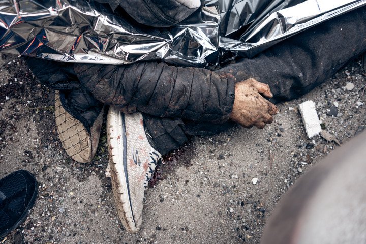 SUMY, UKRAINE - APRIL 13:  Bodies of two people killed in a Russian ballistic missile strike lie covered with an emergency blanket at the strike site on April 13, 2025 in Sumy, Ukraine. The death toll after Russian ballistic missiles' attack on the center of Sumy has risen to 34, including two children. At least 117 people have been injured, including 15 children. On Palm Sunday, the Russian army launched two ballistic missiles with cluster munition at the central part of the city at a time when there were many people on the streets - dozens of people were killed and injured in the city; civilian infrastructure and residential buildings were damaged or destroyed. (Photo: Yehor Kryvoruchko/Kordon via Getty Images)