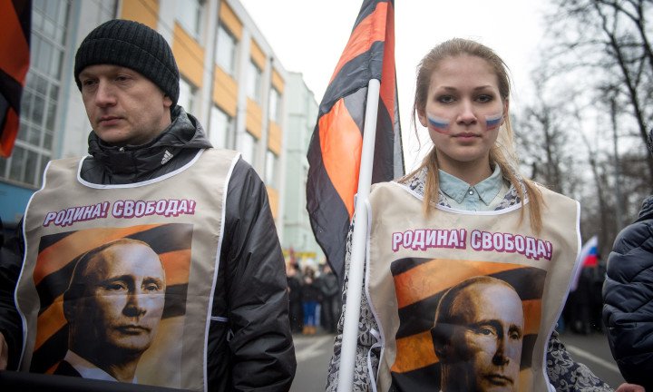 Activistas pro-Kremlin que visten chalecos con retratos de Vladimir Putin bajo el lema "¡Patria y Libertad!" Foto: DMITRY SEREBRYAKOV/AFP vía Getty Images.