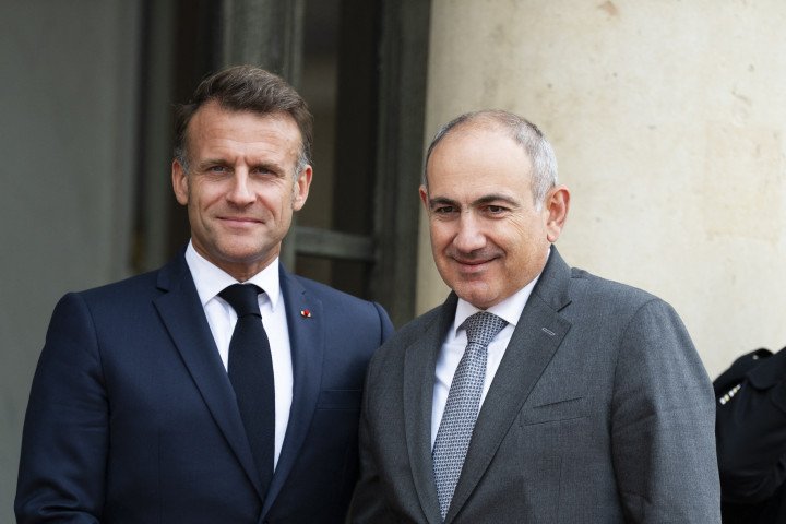 France s President Emmanuel Macron (L) welcomes Armenia s Prime Minister Nikol Pashinyan at the presidential Elysee Palace prior their meeting in Paris on July 14, 2025. (Photo by MAGALI COHEN/Hans Lucas/AFP via Getty Images)