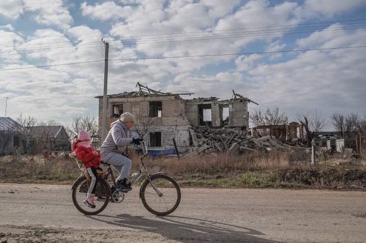 A woman and a child on a bicycle ride past a destroyed house in Posad-Pokrovske, Kherson region, Ukraine. Posad-Pokrovske continues to be rebuilt after liberation from the Russian army. (Photo by Yevhenii Vasyliev, Getty) A woman and a child on a bicycle ride past a destroyed house in Posad-Pokrovske, Kherson region, Ukraine. Posad-Pokrovske continues to be rebuilt after liberation from the Russian army. (Photo by Yevhenii Vasyliev, Getty)