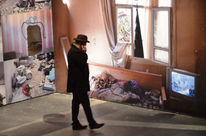 Senior reporter for Libération Jean-Pierre Perrin stands in front of Laurent van der Stockt reconstructed Syrian interior (Source: Geneviève Delalot / L'œil de l'info)