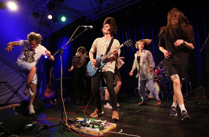 Predominantly Ukrainian audience members dance on stage as the band Love 'n' Joy performs at a music event organized by Vitsche. (Photo by Adam Berry/Getty Images)