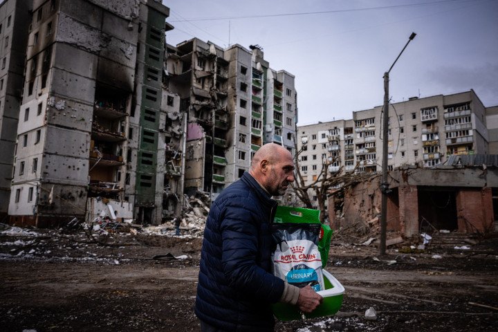 A man walks in front of a residential building damaged in yesterday's shelling in the city of Chernihiv on March 4, 2022. (Photo by DIMITAR DILKOFF/AFP via Getty Images)