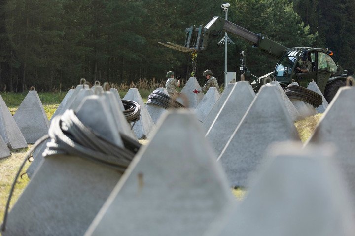 Concrete anti-tank barriers are prepared for installation as Lithuanian troops fortify the border zone. Coiled steel cables and surveillance equipment can be seen nearby. (Source: Lithuanian Armed Forces / Facebook)