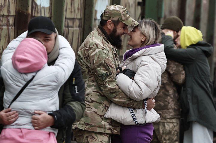 Soldados ucranianos abrazan a mujeres en el andén de la estación de tren el 3 de noviembre de 2024 en Kramatorsk, Ucrania. (Fuente: Getty Images)