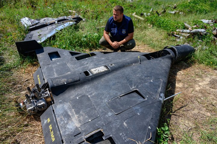 An employee of the Kharkiv Regional Prosecutor’s Office examines the remains of a Shahed-136 drone. (Source: Getty Images)