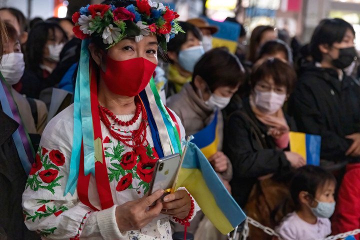 A woman dressed in a traditional attire holds a Ukrainian flag during the concert at Ikebukuro Nishiguchi Park Outdoor Theater "Global Ring Theater". 'Ukraine Support Concert - Love against War' the concert offers to Ukraine and the world the prayers of the residents of Toshima City and the people of Japan. (Photo by Viola Kam/SOPA Images/LightRocket via Getty Images)