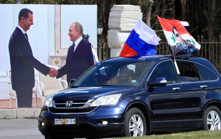 Syrians wave flag of Russia and a portrait of President Bashar al-Assad during a rally in support of Russia in the Syrian capital Damascus (Source: Louai Beshara via Getty Images) Syrians wave flag of Russia and a portrait of President Bashar al-Assad during a rally in support of Russia in the Syrian capital Damascus (Source: Louai Beshara via Getty Images)