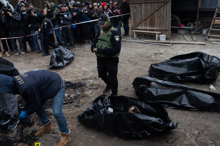 El 5 de abril de 2022, en Bucha, región de Kiev, Ucrania, hombres colocaron cadáveres en bolsas negras tras descubrir las atrocidades cometidas por el ejército ruso en la ciudad. Foto de Yevhenii Zavhorodnii/Global Images Ukraine vía Getty Images.
