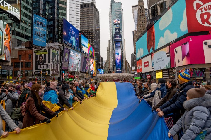 Protesters hold a Ukrainian flag banner during a demonstration against the Russian invasion of Ukraine in the Times Square neighborhood of New York, U.S. Photographer : Amir Hamja/Bloomberg via Getty Images