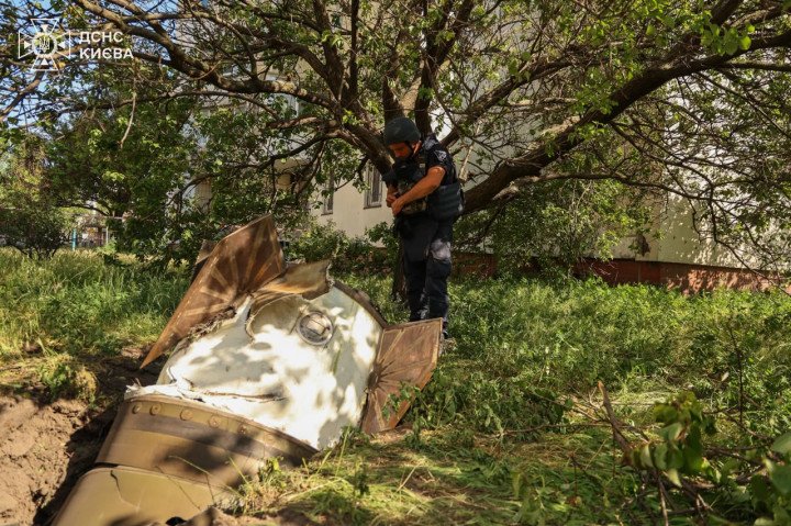 An explosives specialist inspects the unexploded remains of a Russian missile that landed near a residential building in Kyiv's Darnytskyi district following the June 28 attack. (Source: State Emergency Service of Ukraine)
