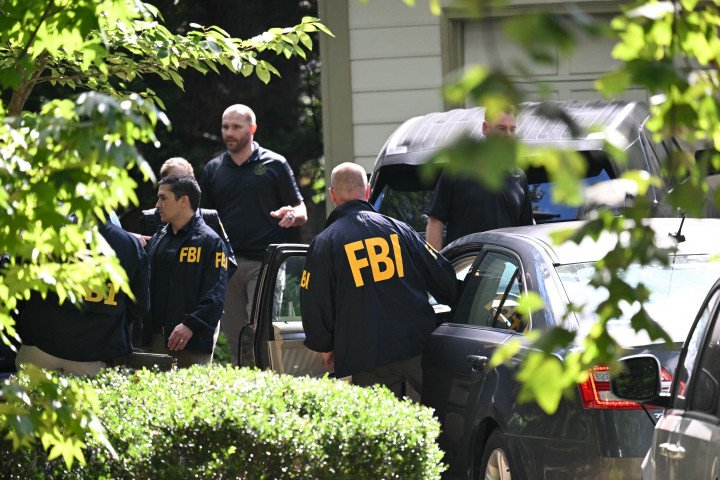 FBI agents stand outside the Bethesda home of former National Security Advisor John Bolton during a court‑authorized search on August 22, 2025. (Source: Getty Images) FBI agents stand outside the Bethesda home of former National Security Advisor John Bolton during a court‑authorized search on August 22, 2025. (Source: Getty Images)