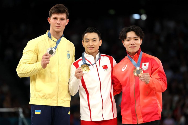 Gold medalist Jingyuan Zou of Team People’s Republic of China (C), silver medalist Illia Kovtun of Team Ukraine (L) and bronze medalist Shinnosuke Oka of Team Japan (R) pose on the podium at the Artistic Gymnastics Men’s Parallel Bars Medal Ceremony on day ten of the Olympic Games Paris 2024 at Bercy Arena on August 05, 2024 in Paris, France. (Source: Getty Images) Gold medalist Jingyuan Zou of Team People’s Republic of China (C), silver medalist Illia Kovtun of Team Ukraine (L) and bronze medalist Shinnosuke Oka of Team Japan (R) pose on the podium at the Artistic Gymnastics Men’s Parallel Bars Medal Ceremony on day ten of the Olympic Games Paris 2024 at Bercy Arena on August 05, 2024 in Paris, France. (Source: Getty Images)