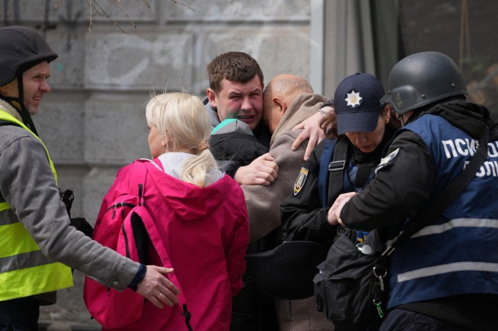 SUMY, UKRAINE - APRIL 13: Two men comfort each other as Ukrainian police psychologists provide assistance to local residents following a missile attack in Sumy, northeastern Ukraine, on April 13, 2025, amid the Russian invasion of Ukraine. A Russian ballistic missile attack on Ukraine's northeastern city of Sumy killed at least 31 people and wounded 84 on Palm Sunday, Kyiv said, in another deadly attack on civilians that came after a top US official travelled to Russia. (Photo: OLEG VORONENKO via Getty Images)