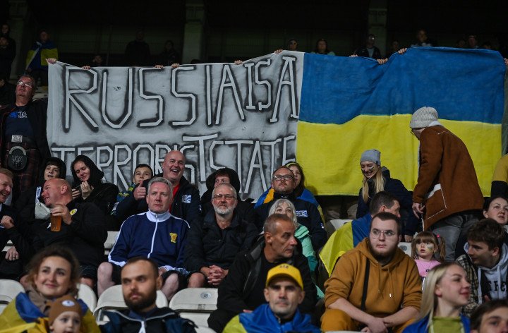 Fans from Ukraine hold a banner 'Russia Is A Terrorist State' during the UEFA Nations League 2022/23 match between Ukraine and Scotland on September 27, 2022, in Poland. (Photo by Artur Widak/NurPhoto via Getty Images).