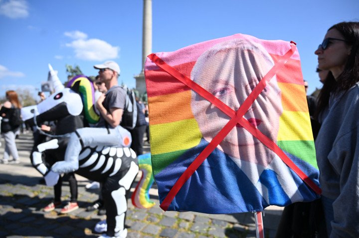 A sympathiser of small, satirical "Two-tailed Dog Party" holds a crossed out picture of Hungarian Prime Minister Viktor Orbán during a "Gray Pride Demo" to ridicule Orbán’s clampdown on LGBTQ rights and diversity. (Source: Attila Kisbenedek via Getty Images) A sympathiser of small, satirical "Two-tailed Dog Party" holds a crossed out picture of Hungarian Prime Minister Viktor Orbán during a "Gray Pride Demo" to ridicule Orbán’s clampdown on LGBTQ rights and diversity. (Source: Attila Kisbenedek via Getty Images)