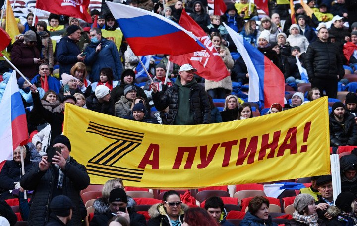 On March 18, 2022, people assembled at Moscow's Luzhniki Stadium for a concert commemorating the eighth anniversary of Russia's annexation of Crimea. A banner displaying the letter "Z" in the colors of the Saint George ribbon featured the slogan "For Putin!" (Source: Getty.)