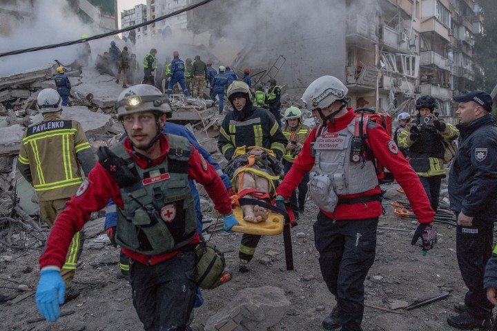 Rescuers evacuate an injured civilian from a damaged residential building following a Russian drone and missile attack on Kyiv, Ukraine, May 14, 2026. (Source: Getty Images)