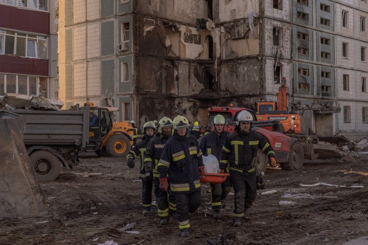 Emergency workers carry on a stretcher a body of a victim found under the rubble of the destroyed residential building following the Russian attack, on April 28, 2023 in Uman, Ukraine. (Photo by Roman Pilipey/Getty Images)