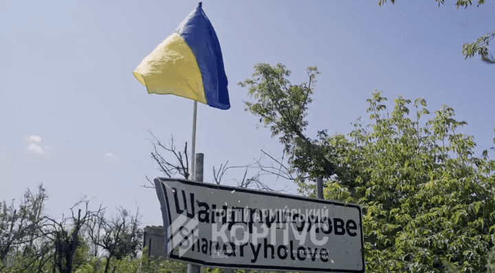 A Ukrainian flag flies above a road sign in Shandryholove following the village’s liberation by Ukrainian forces.