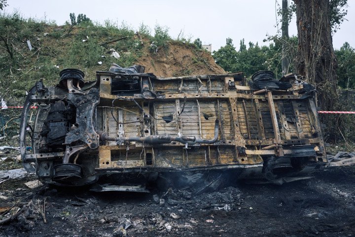 A car lies flipped and charred after a Russian weapon exploded nearby during the overnight assault on the capital. The blast radius extended across multiple residential neighborhoods. Kyiv, Ukraine. July 31, 2025. Photo by Josh Olley/UNITED24 Media