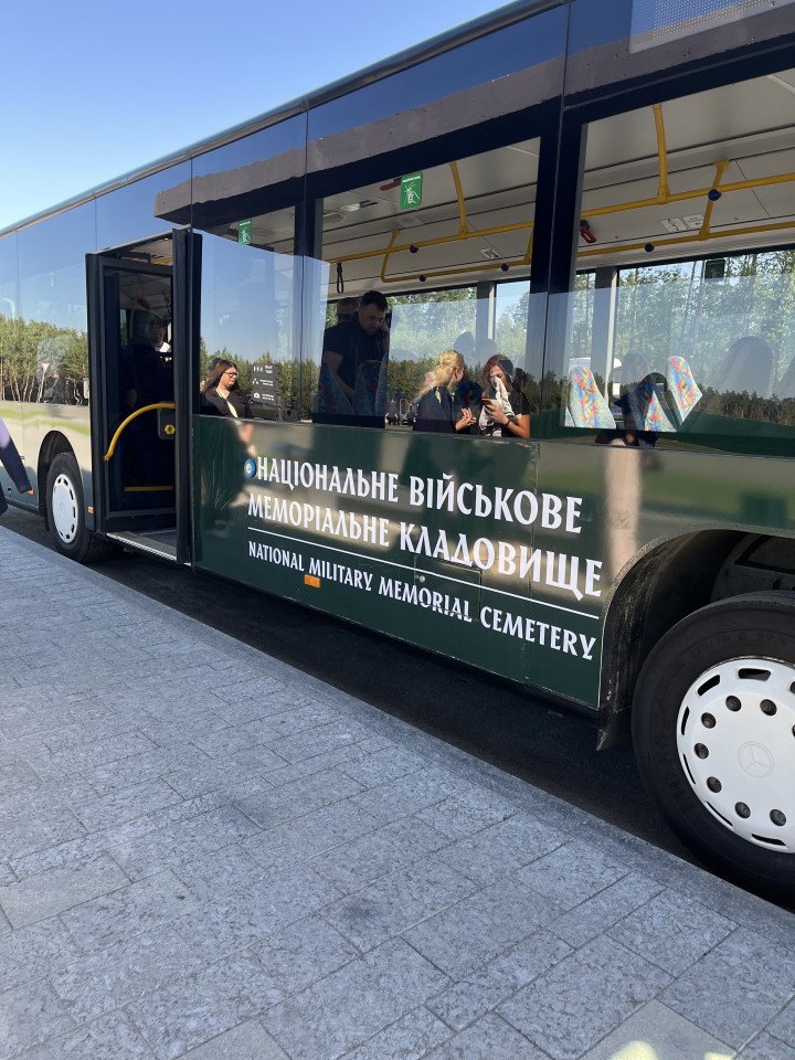 Shuttle bus marked “National Military Memorial Cemetery” transporting visitors to the site in Kyiv region, Ukraine on August 29, 2025. (Source: Amira Barkush for UNITED24 Media)