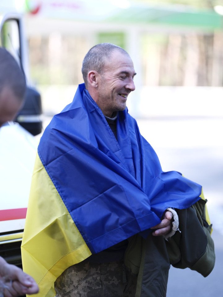 A Ukrainian defender smiles after being released from Russian captivity, wearing the national flag. (Source: Zelenskyy/Telegram) A Ukrainian defender smiles after being released from Russian captivity, wearing the national flag. (Source: Zelenskyy/Telegram)
