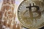 A souvenir crypto token is seen pictured with a 100 ruble bill in Moscow on July 30, 2024.