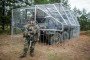 Bundeswehr soldier Marcus stands next to a Fuchs armored personnel carrier in front of the makeshift drone defense cage he designed and built himself during the “Freedom Shield 2026” combat exercise in Lithuania. (Source: Getty Images)