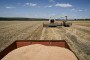 A combine harvester collects winter wheat as trucks are parked nearby in the field in Zaporizhzhia district, Zaporizhzhia region, Ukraine, July 18, 2026. (Source: Getty Images)
