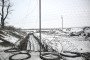 An anti-tank trench reinforced by barbed wire is seen through an anti-drone net covering the road to protect from Russian FPV drone strikes in the Donetsk region, Ukraine, on January 23, 2026. (Source: Getty Images)