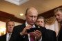 Russian leader Vladimir Putin holds an iPhone as his spokesman Dmitry Peskov looks on at the APEC Leaders Summit on November 10, 2017 in Da Nang, Vietnam.