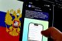 The MAX app logo is displayed on a mobile phone screen in front of a Russian flag as a person uses the application in Moscow, Russia. (Source: Getty Images)