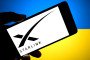 In this photo illustration, a Starlink logo is seen displayed on a smartphone with the Ukrainian flag in the background. (Source: Getty Images)
