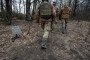 Soldiers of the Ukrainian 95th Brigade walk past a Starlink satellite internet receiver in the Lyman direction on February 18, 2024, in an undisclosed location in Ukraine.