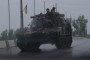 Ukrainian servicemen drive on an armored vehicle along a road covered with an anti-drone mesh corridor on May 17, 2026, in Druzhkivka, Donetsk region, Ukraine.