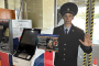 A life-size police figure stands beside an ATM as part of a campaign warning customers about telephone fraud and urging them not to transfer money to scammers. (Photo: open source)
