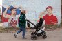 A woman pushes a baby stroller past patriotic graffiti featuring the Russian flag in Krasnogorsk, a suburb of Moscow, Russia, on April 10, 2023. (Source: Getty Images)