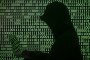 A person works on his computer in front of binary digits. (Source: Getty Images)