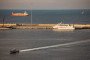 A police speed boat patrols the port as oil tankers and high speed crafts sit anchored at Muscat Anchorage near the Strait of Hormuz. (Source: Getty Images)