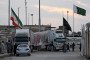 PAKISTAN-IRAN-US-ISRAEL-CONFLICT An Iranian cargo truck crosses into the Pakistan-Iran border as an Iranian national flag (L) flies at half-mast at Taftan, Balochistan province on March 1, 2026 after the death of Iran's supreme leader Ayatollah Ali Khamen