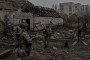 Ukrainian soldiers walk past destroyed vehicles in the frontline city of Kostiantynivka, Donetsk region, on October 16, 2025. (Source: Getty Images)