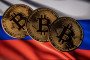 Illustrative image: a novelty Bitcoin token is photographed with a Russian flag. (Source: Getty Images)