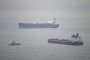 A tanker passes a border security vessel and the detained Smyrtos vessel outside the harbour. (Source: Getty Images)
