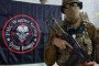 A suspected Wagner Group fighter poses with a rifle in front of a Wagner flag. (Photo: Open source)