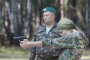 A girl practices pistol shooting during a training exercise in the forest. (Source: Yale University School of Public Health's Humanitarian Research Lab)