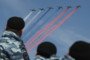 Security personnel watch as Russian air force fighter jets trail the colors of the Russian flag.  (Source: Getty Images)