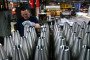 An employee handles 155 mm caliber shells after the manufacturing process. (Source: Getty Images)