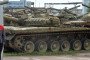 An employee looks at broken tanks parked during an open day at the Armored Vehicle repair plant in Strelna, outside Saint Petersburg, on August 5, 2016.